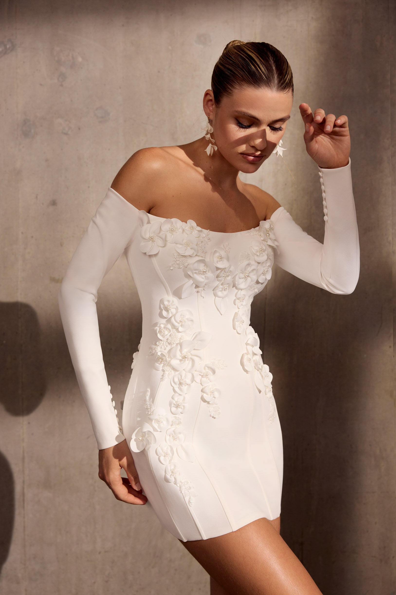 Lux stretch crepe, off-the-shoulder mini dress
with 3D laser applique flowers and dramatic
lace-up back