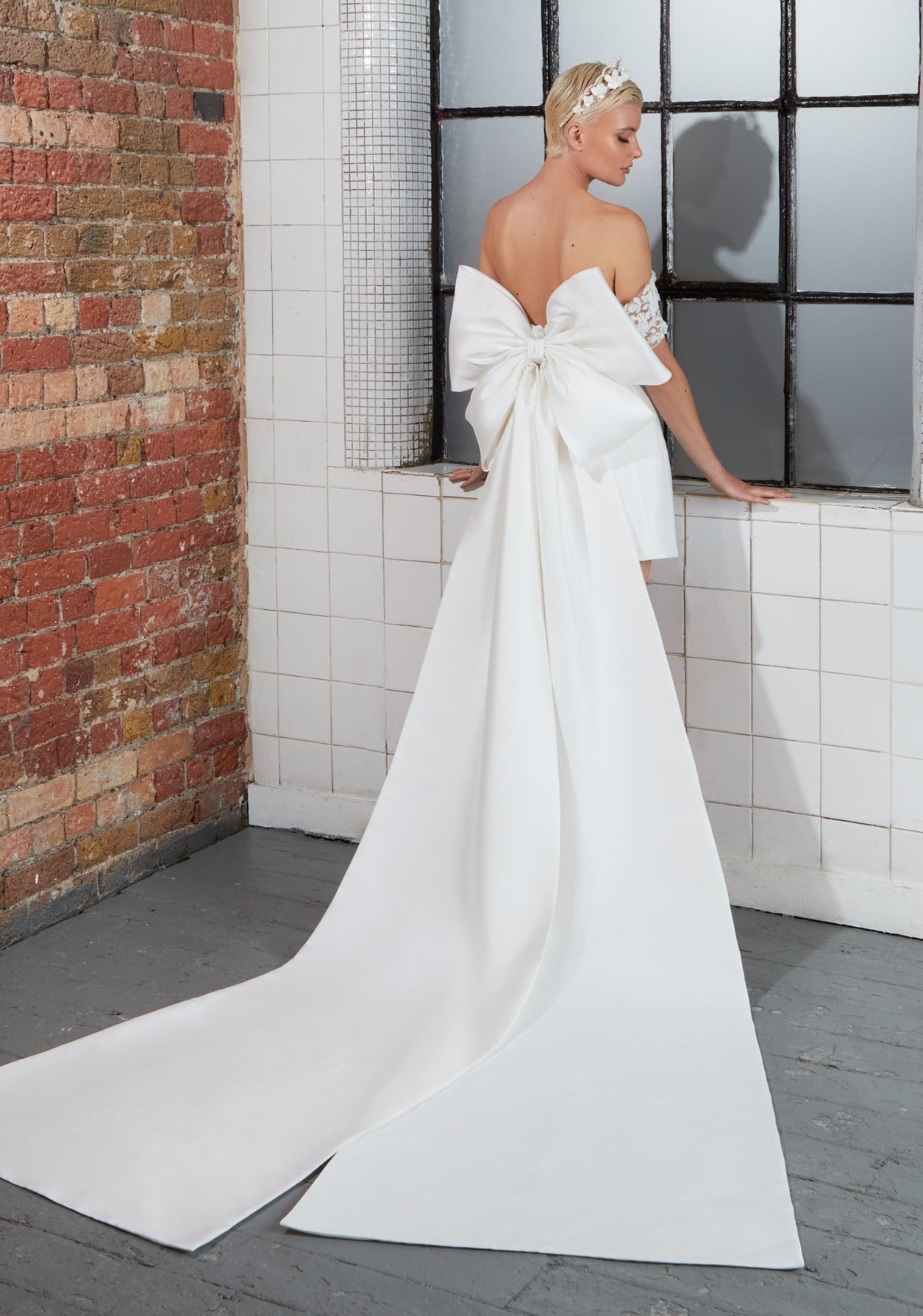 short corseted gown with a detachable oversized bow and beaded lace bust and straps