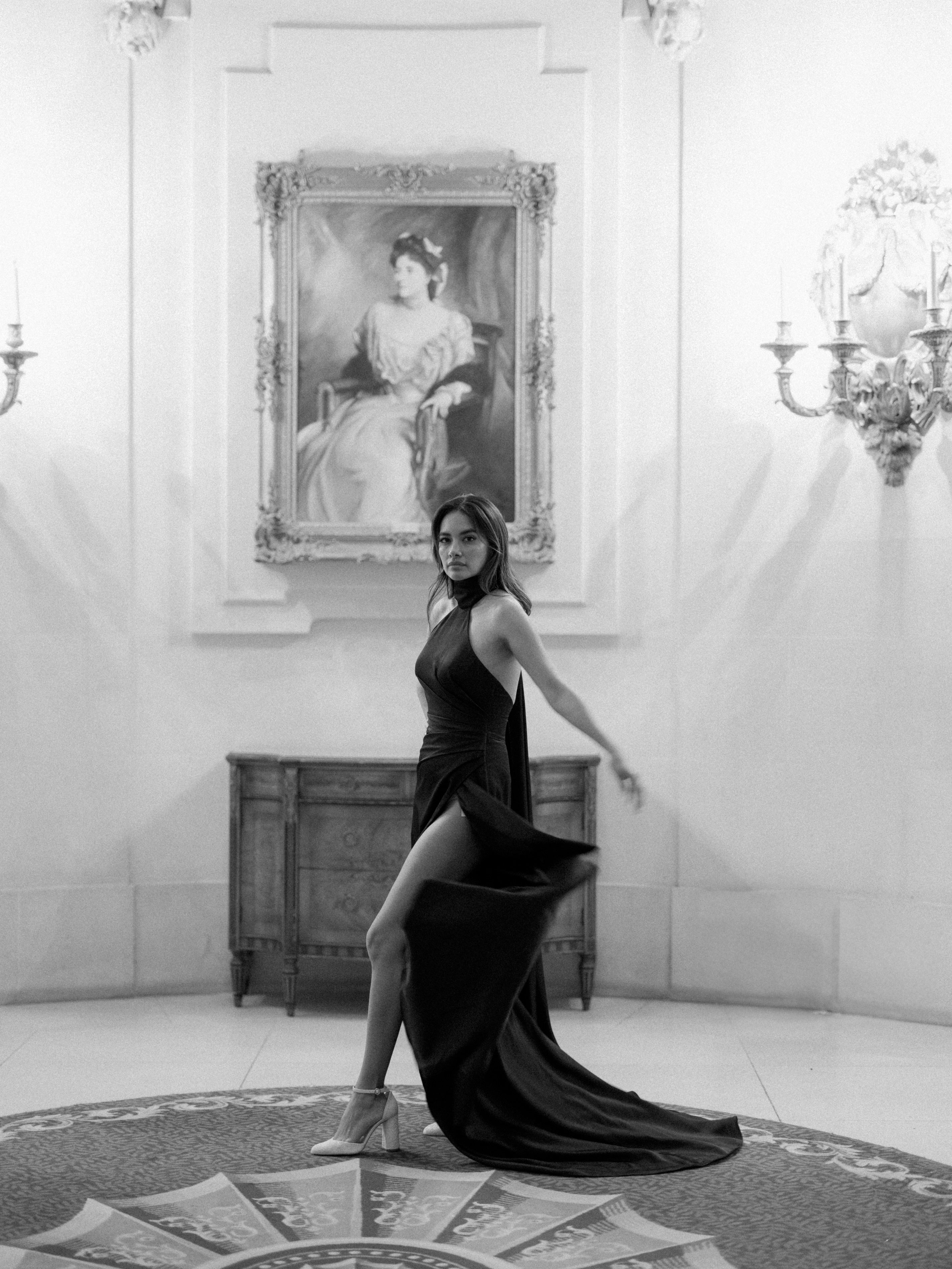 chic satin crepe black noir sheath dress with a flattering high neck and pleats and thigh high split low cut back
