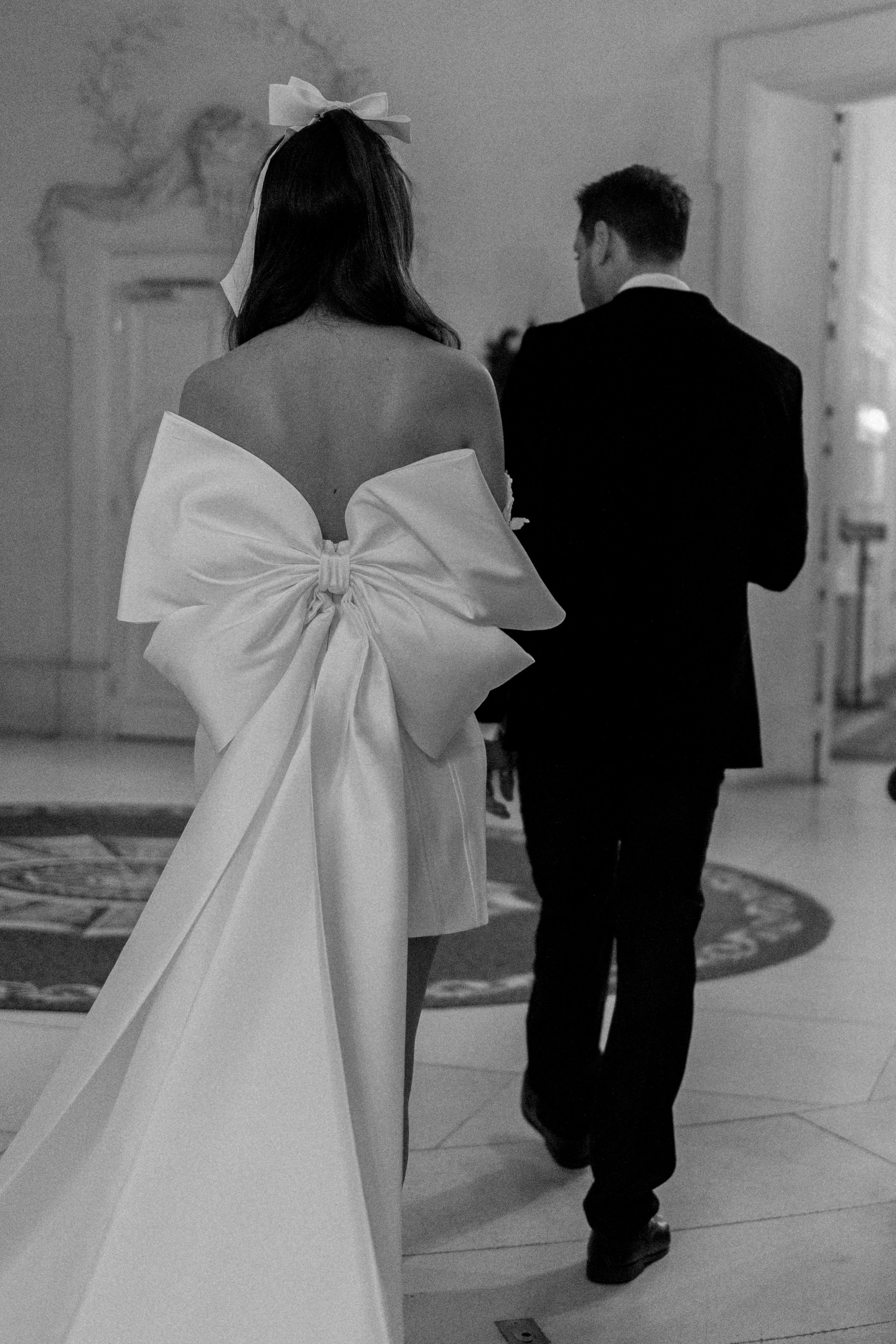 short corseted gown with a detachable oversized bow and beaded lace bust and straps