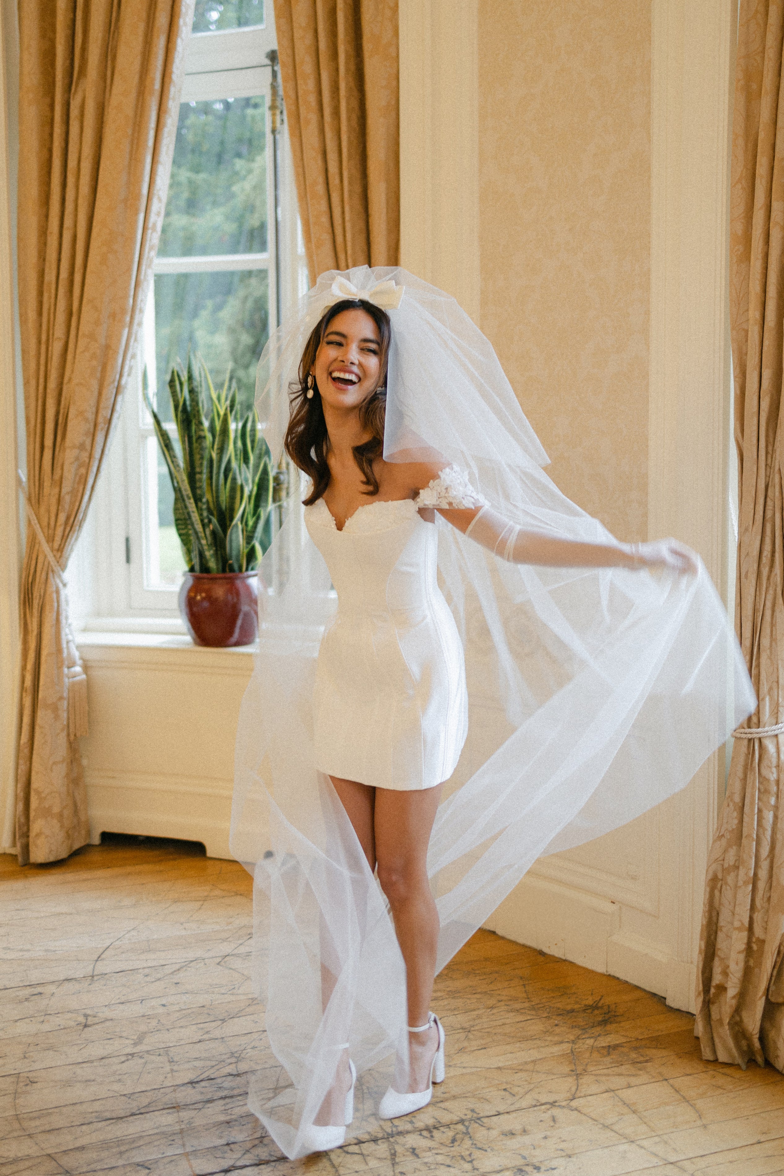 short corseted gown with beaded lace bust and straps and double tier bow wedding veil
