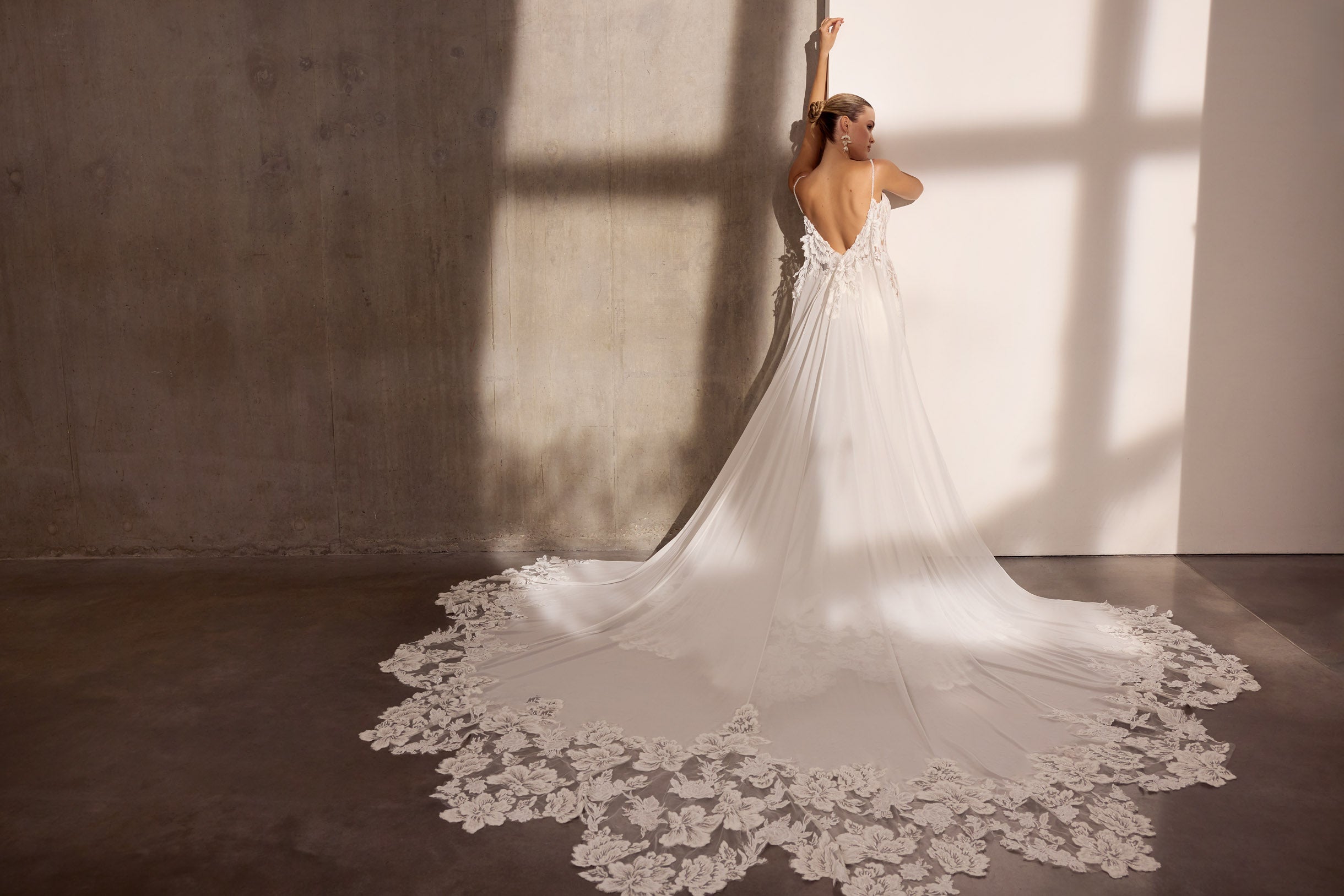 Lux stretch crepe with floral applique and
illusion train. Optional detachable cape