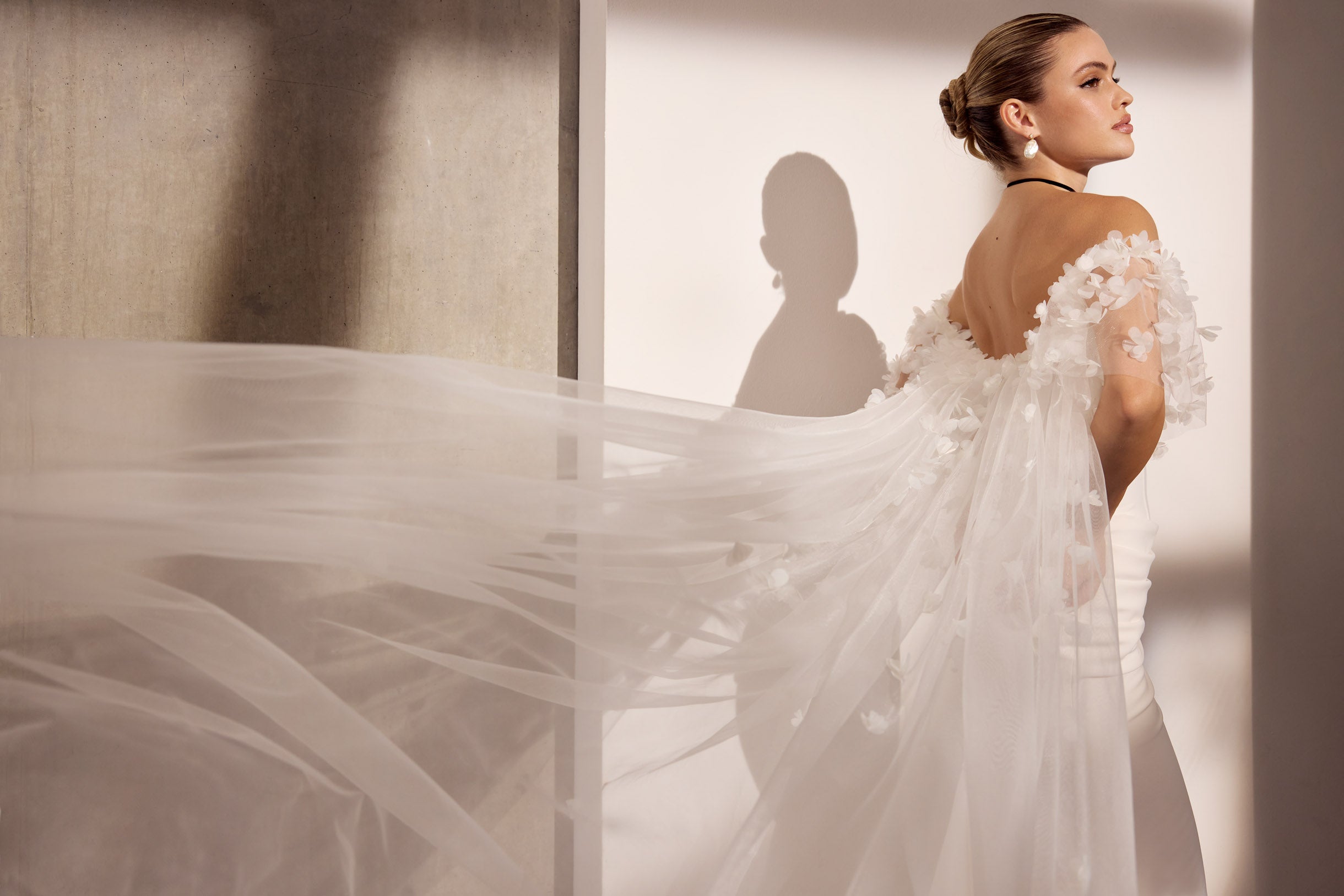 Strapless lux stretch crepe sheath dress with
flattering pleating and boned bodice and 3D flower tulle off the shoulder veil cape