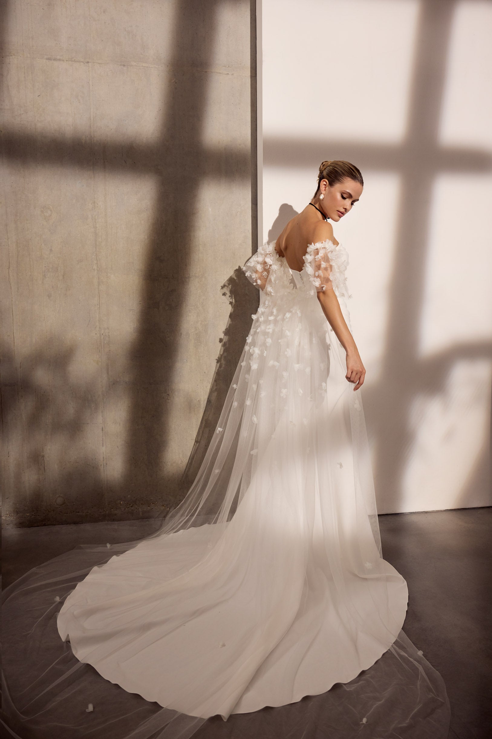 Strapless lux stretch crepe sheath dress with
flattering pleating and boned bodice and 3D flower tulle off the shoulder veil cape