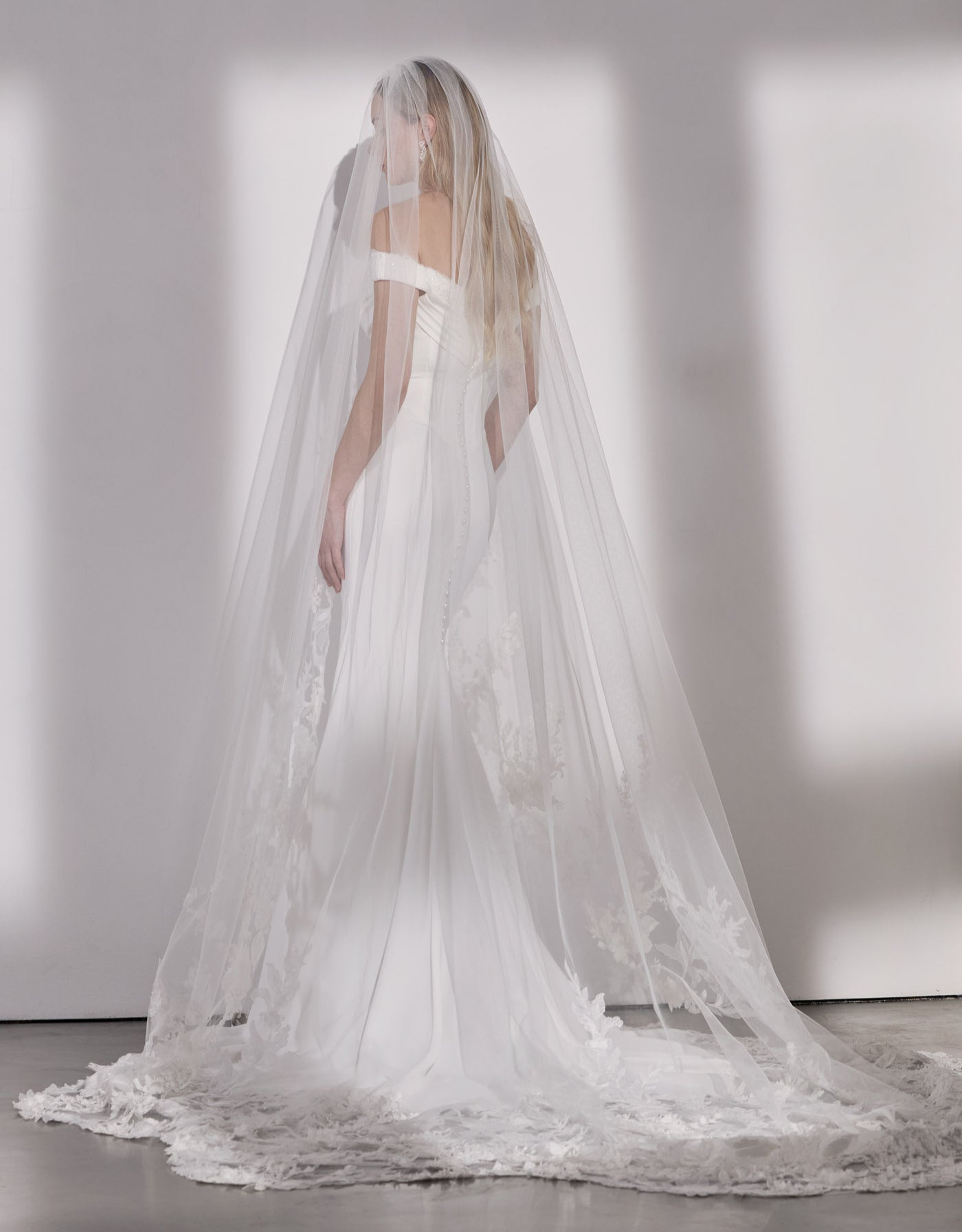 Georgette crepe and French-look lace off-
the-shoulder sheath dress with illusion train with single tier lace veil