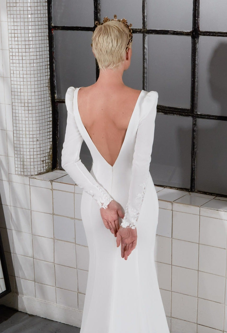 open back plunge V-neckline and fishtail silhouette sheath dress with sleeves and laces cuffs and a dramatic train