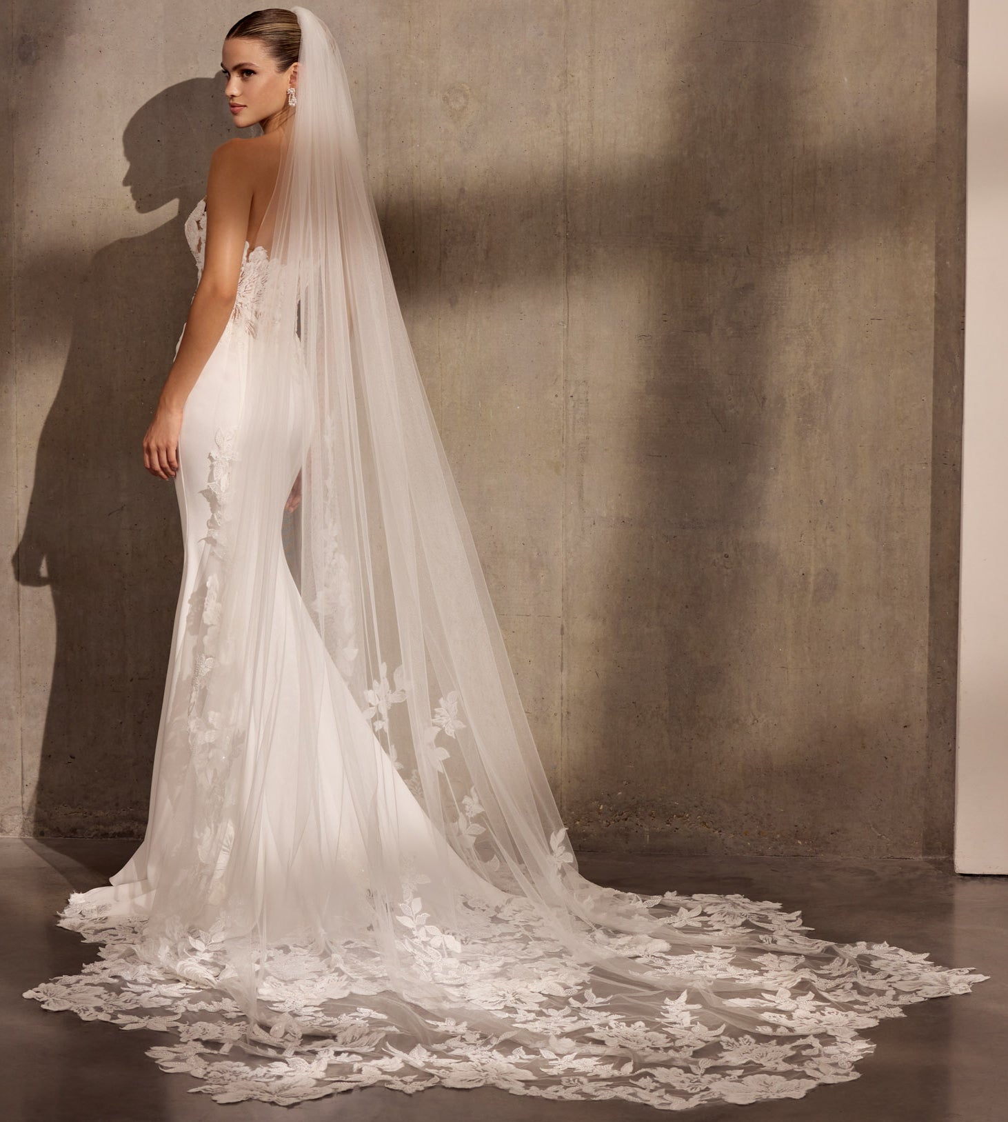 Japanese crepe sheath dress with floral
applique embellishment and illusion train.
Optional detachable applique shrug and single tier lace wedding veil